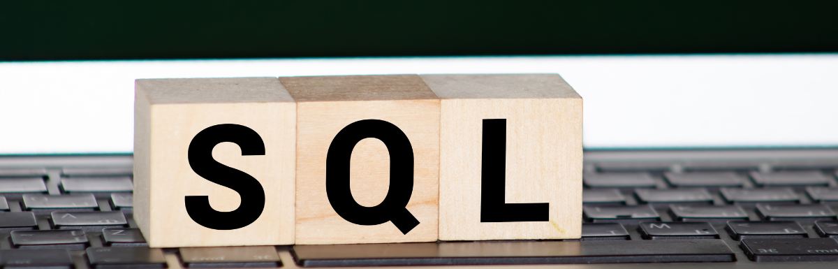 A wooden block with the word SQL on top of a keyboard, representing SQL views.
