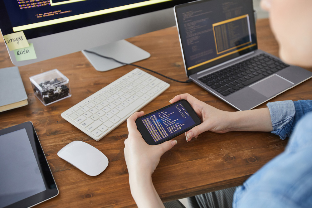 A woman uses an Android emulator on her mobile phone while she is sitting at an office