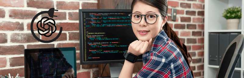 Une femme est assise devant un ordinateur sur lequel figure un code.