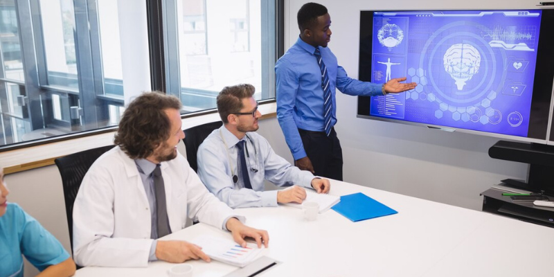 A group of people sitting around a table in a conference room.